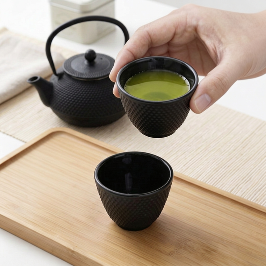 Eine Tasse japanischer Grüntee neben einer Teekanne